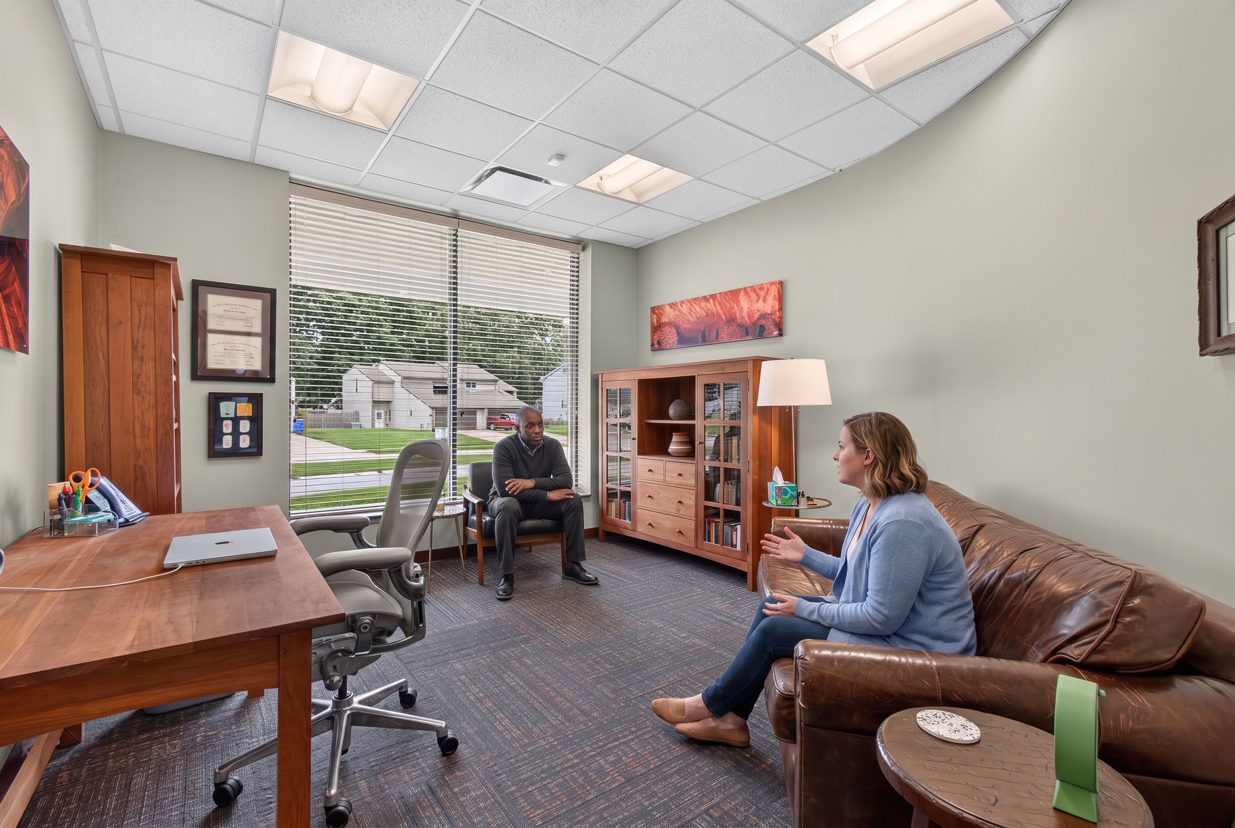 A counselor and client talking across a Genesis counseling room