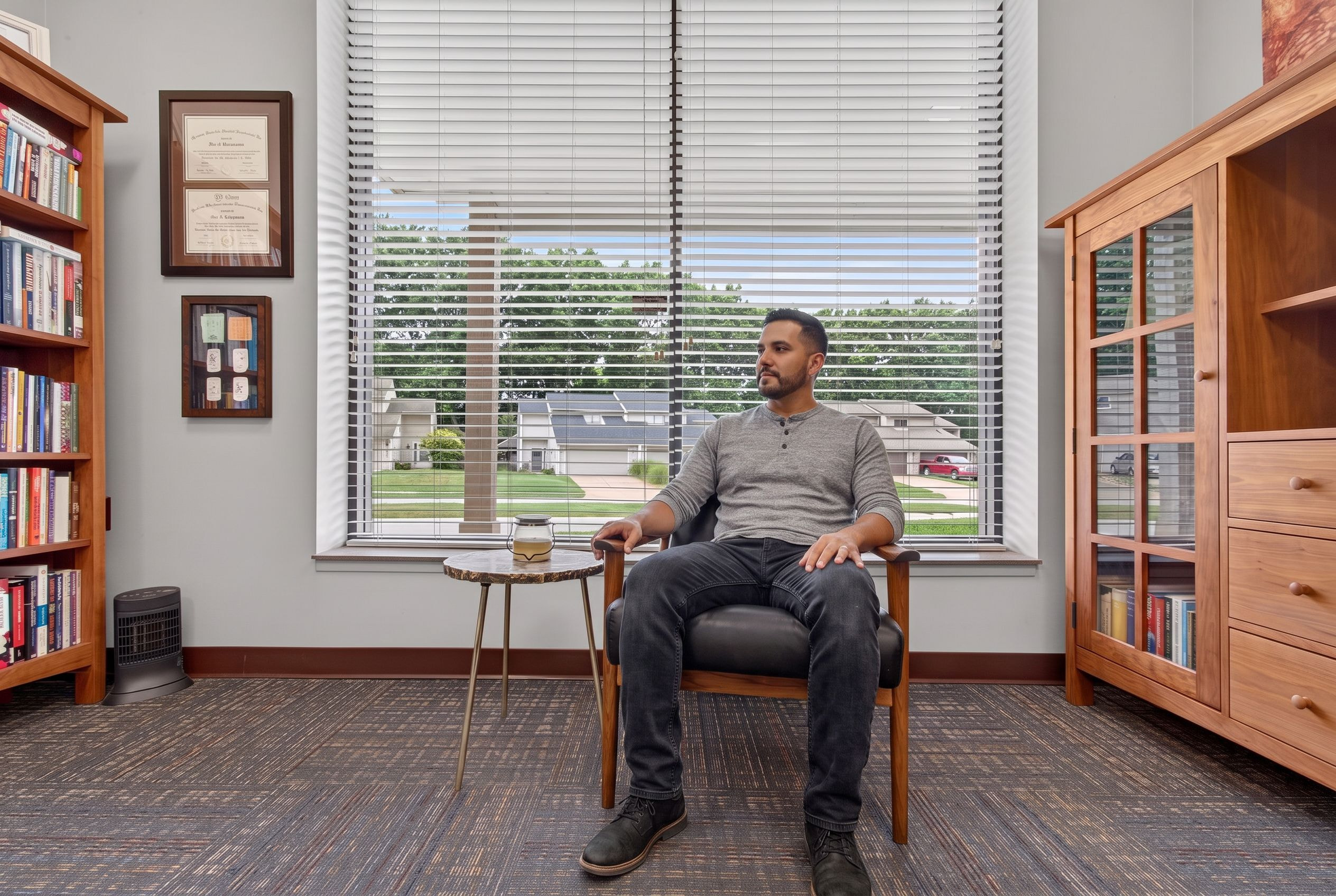 A man in a Genesis counseling room, seated by the window