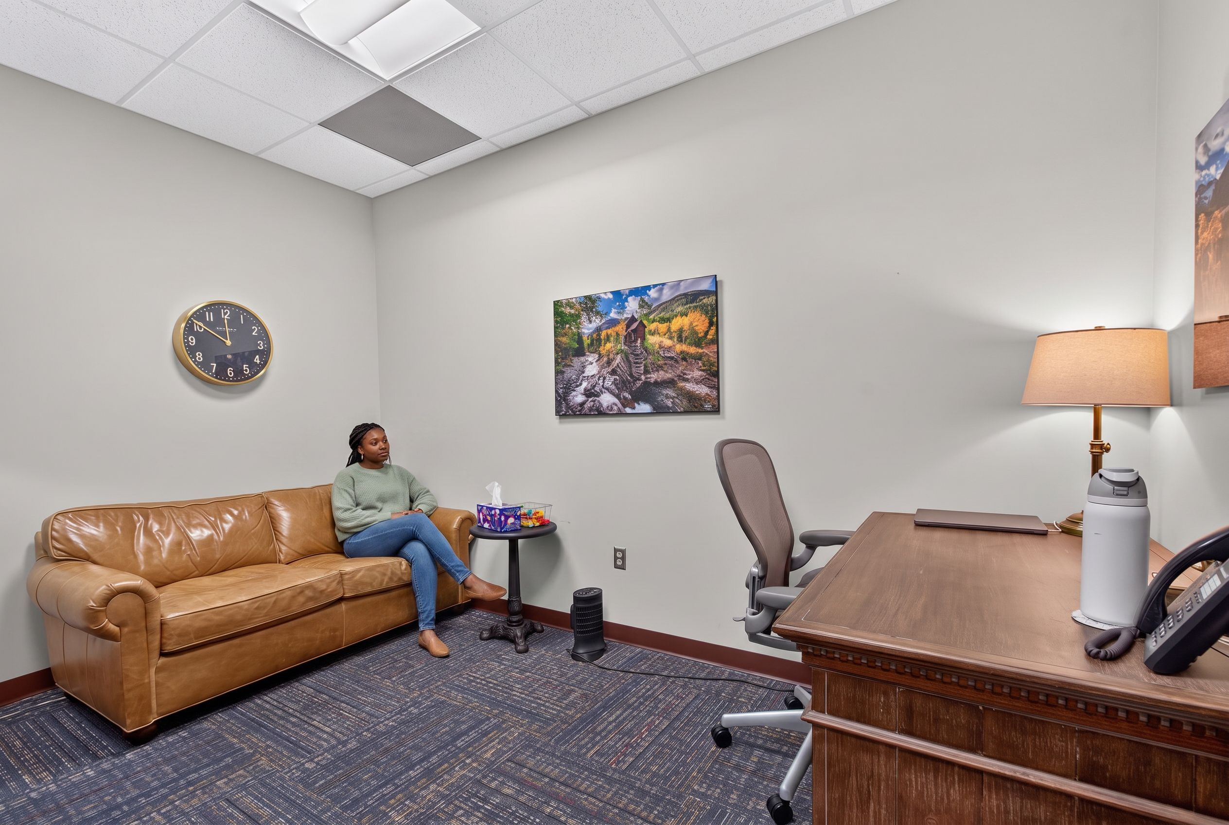 A woman in session on the sofa in a Genesis counseling room