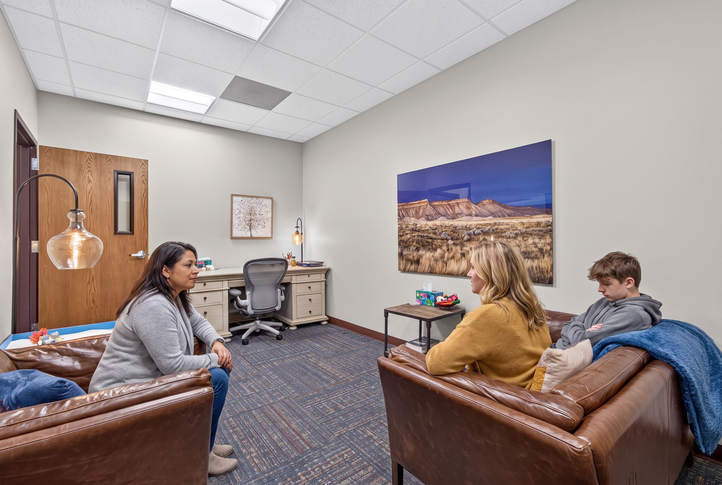 A counselor with a parent and their teenager at Genesis