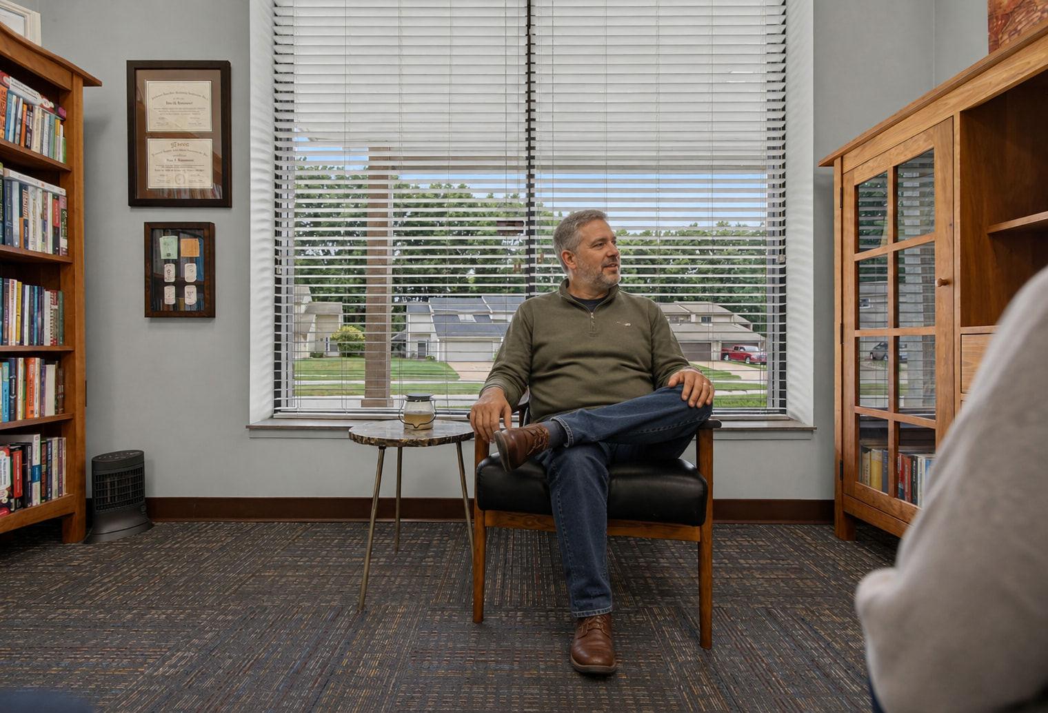 A man in the chair by the window at Genesis, mid-conversation